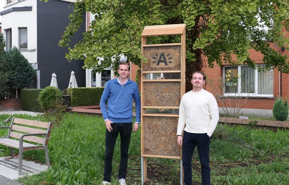 Twee vrienden staan tegenover elkaar in het stemhokje